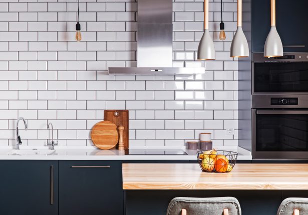 Cuisine moderne et spacieuse avec pose de carrelage mural.